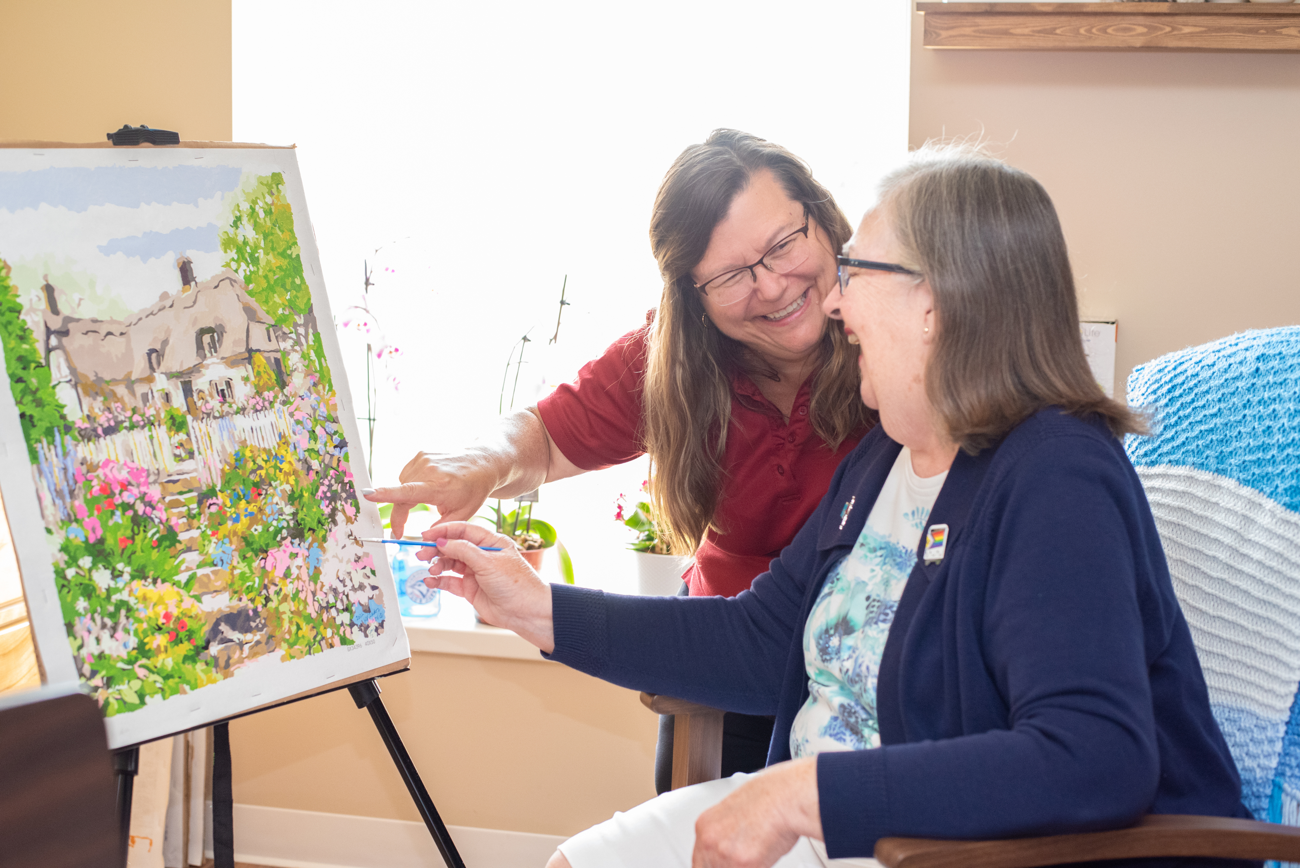 Resident and team member painting together
