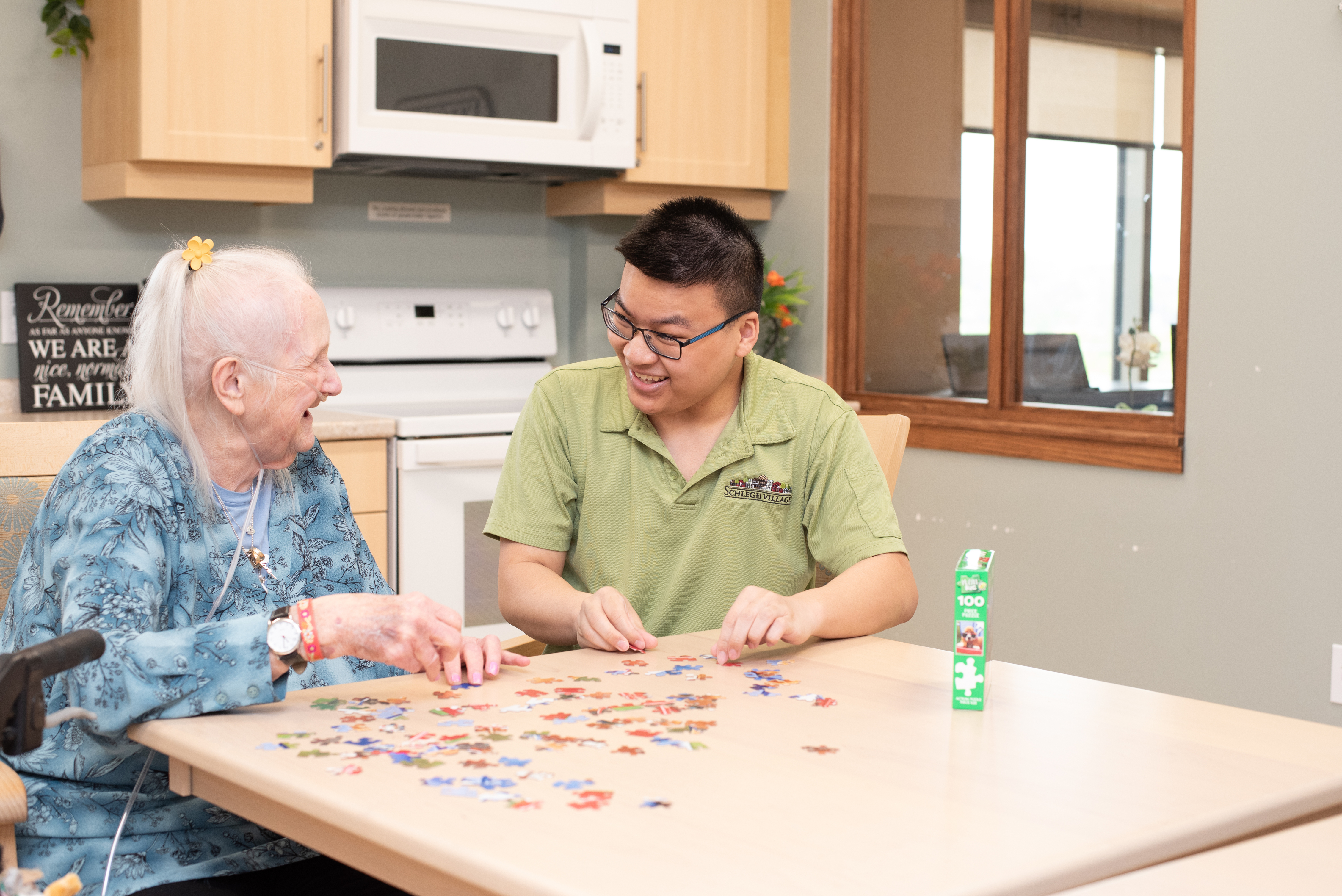 Resident and team member working on a jigsaw puzzle