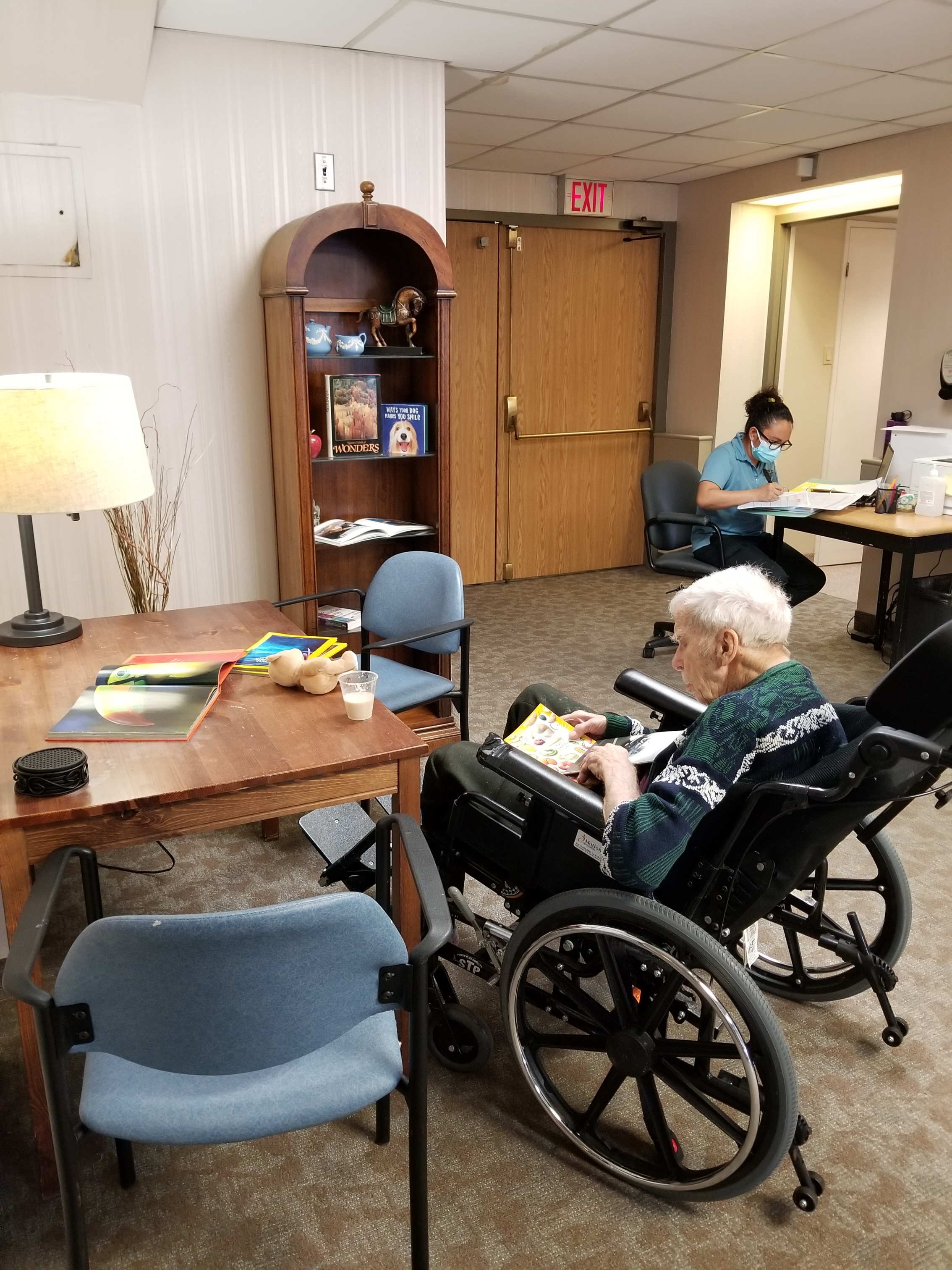 Team Member and Resident reading in the lounge