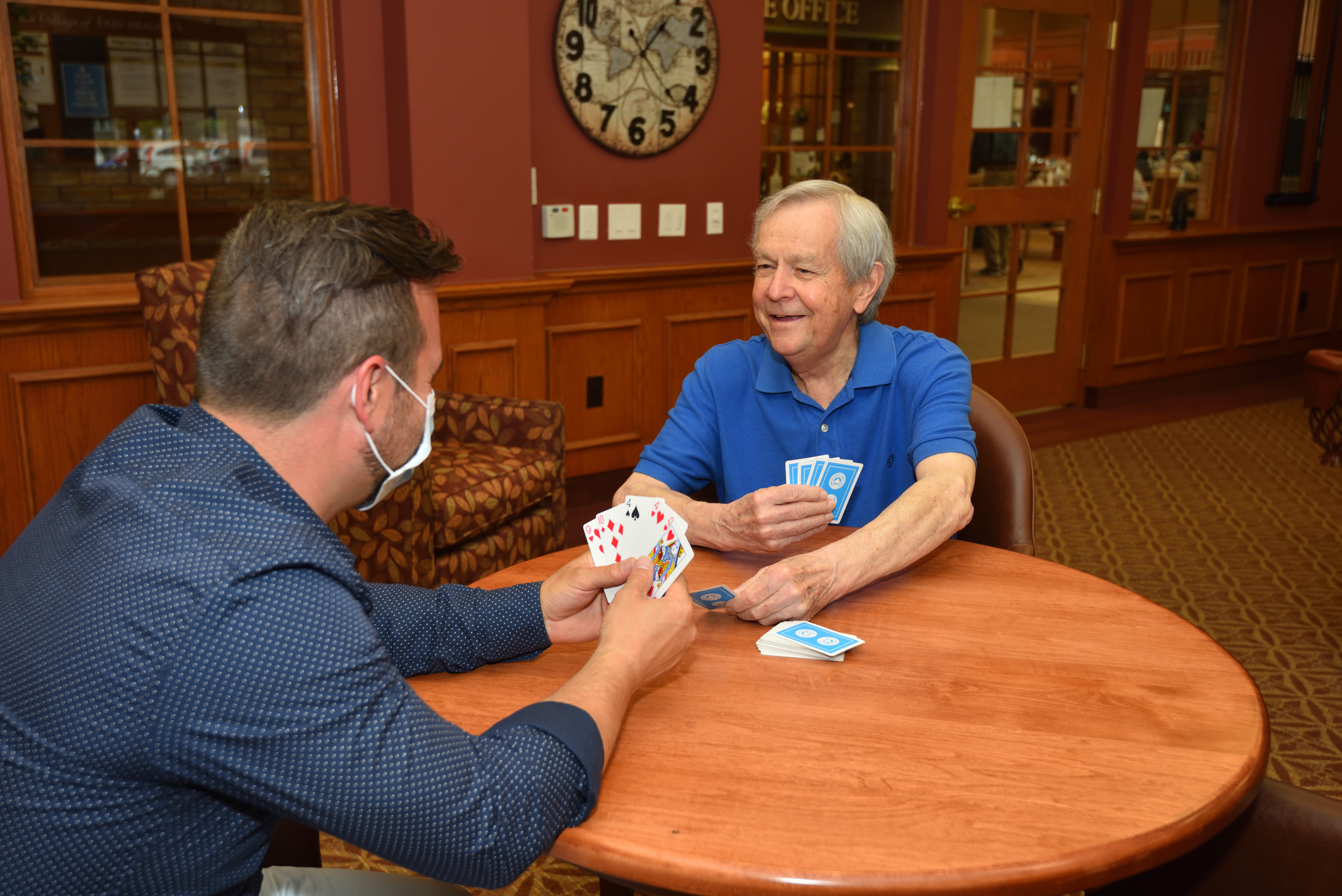 Resident and team member playing cards in the Social Club