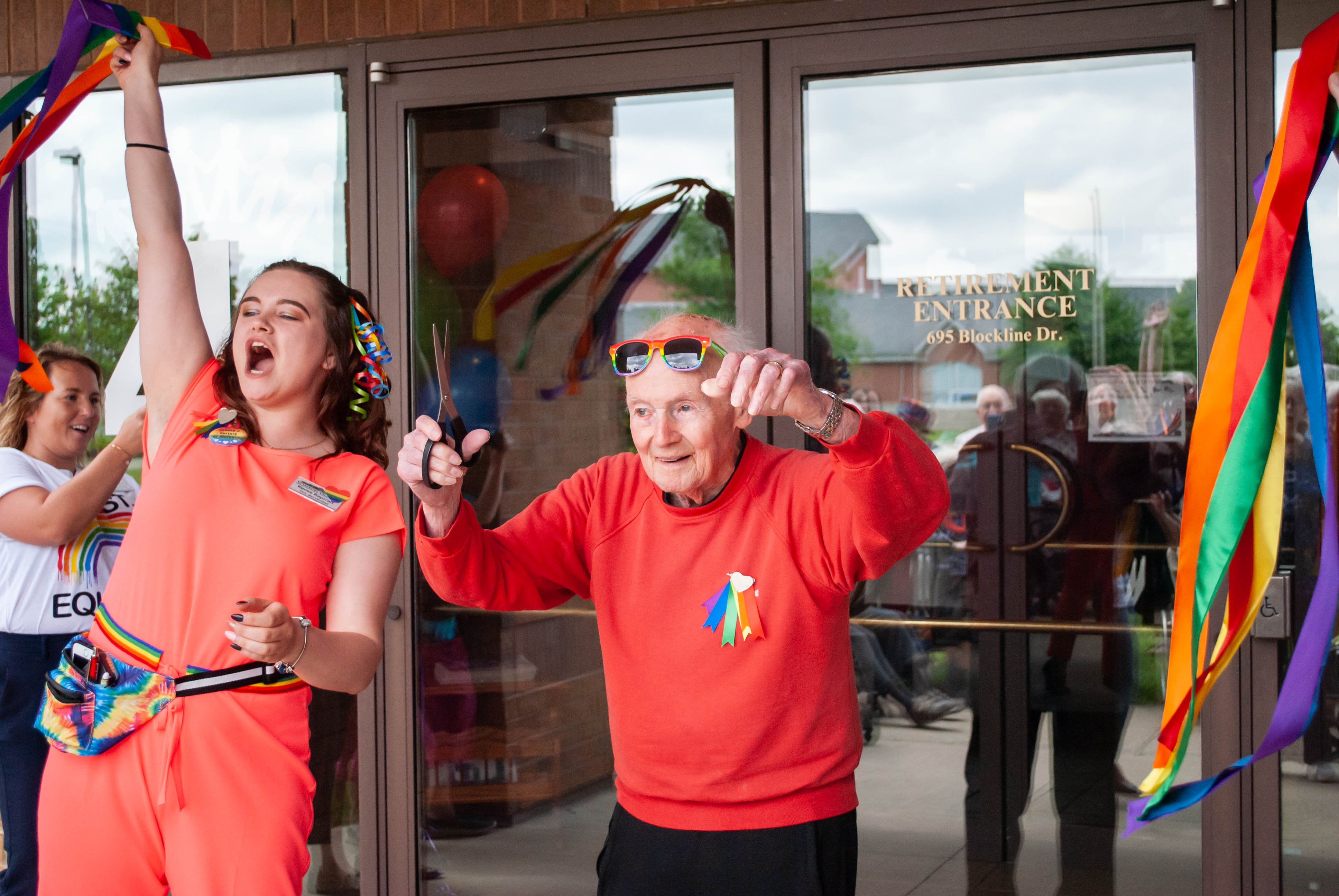 Resident cutting a Pride ribbon for Pride Day