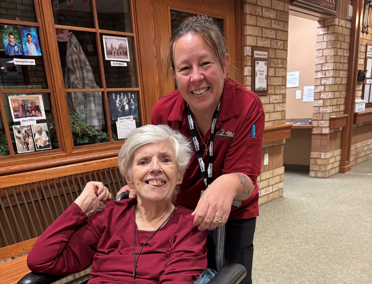 Julie poses with a Wentworth Heights resident, each with wide grins upon their faces.