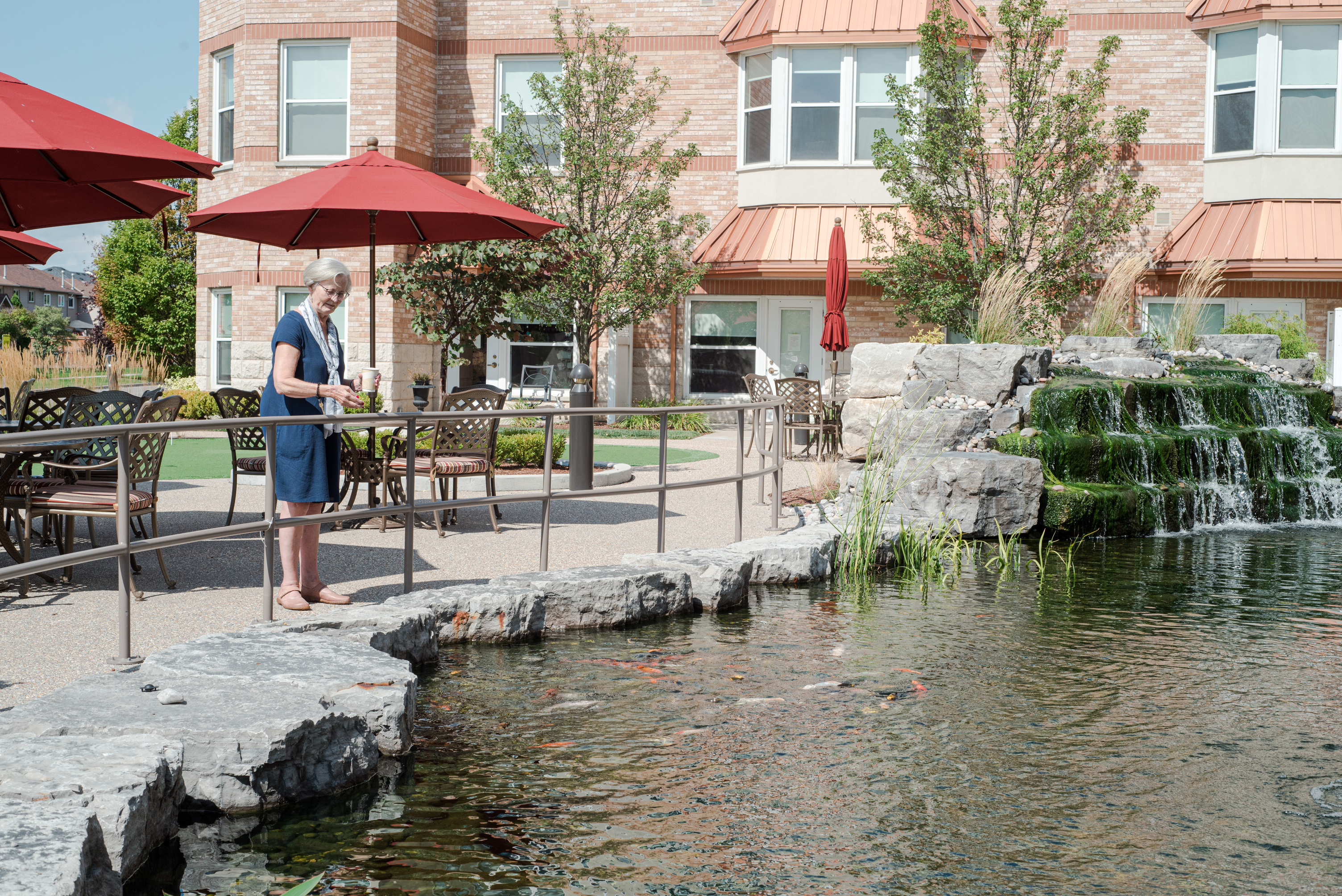 Resident looking at koi fish in Courtyard pond.